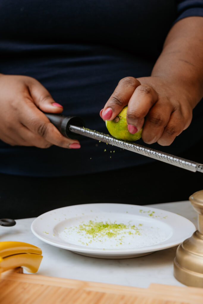 Kandice is zesting lime into margarita salt.