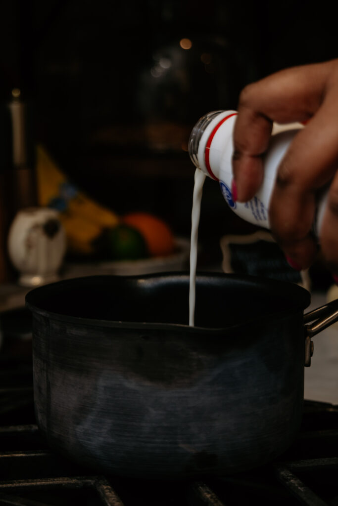 Pouring milk into a sauce pan.