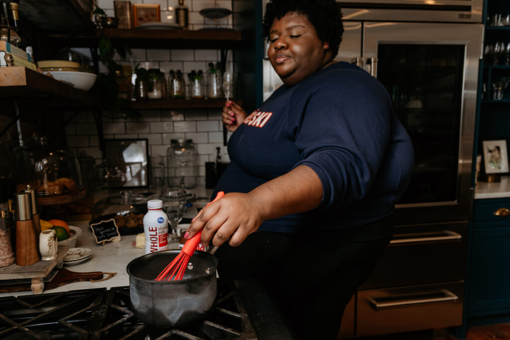 Kandice is whisking nutella into milk.