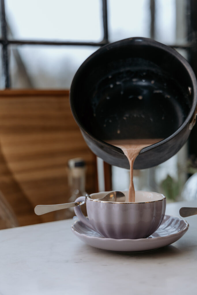 Pouring hot chocolate into teacup.