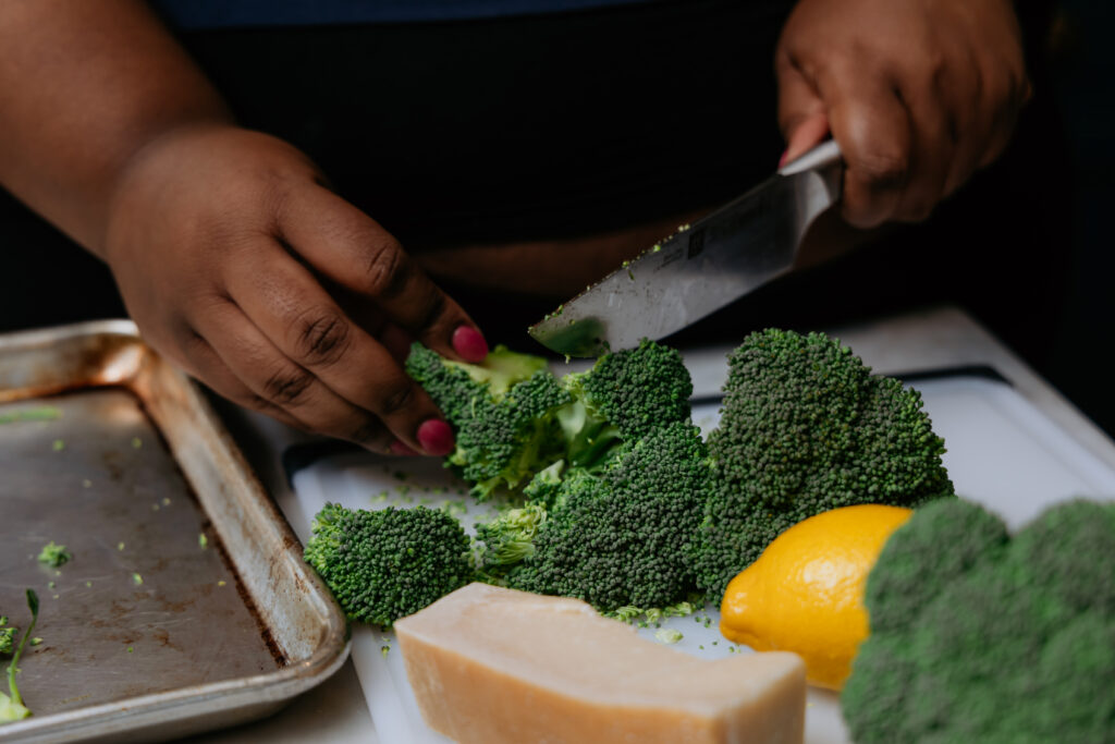 Kandice is slicing broccoli into florets.