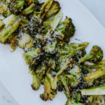 A platter of slow roasted broccoli with lemon and cheese.