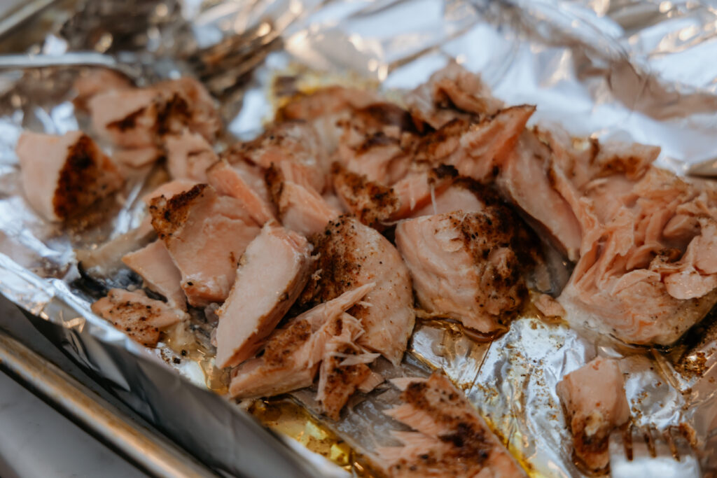 Cooked shredding salmon sitting on a sheet pan.