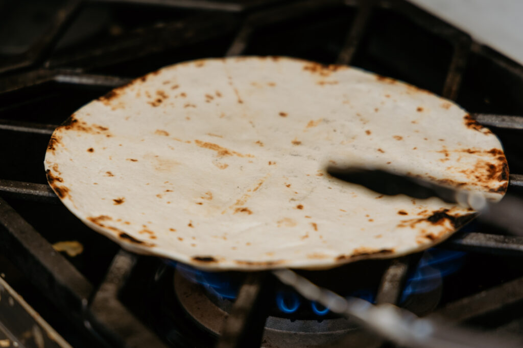 Charred tortilla over open flame.