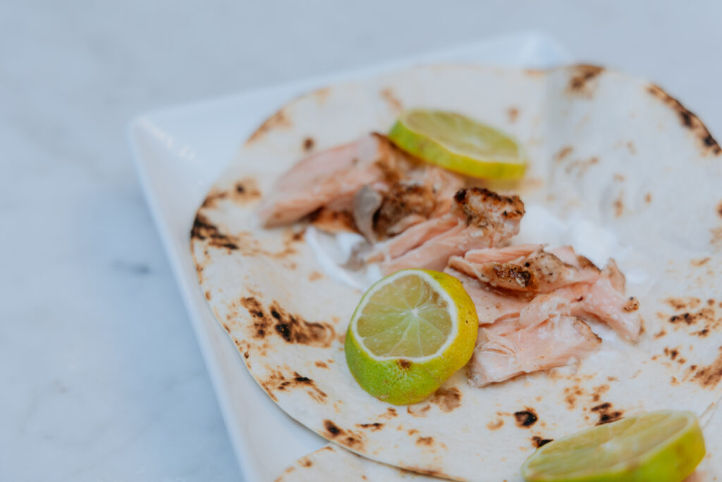 Salmon tacos with lime crema sitting on a platter.