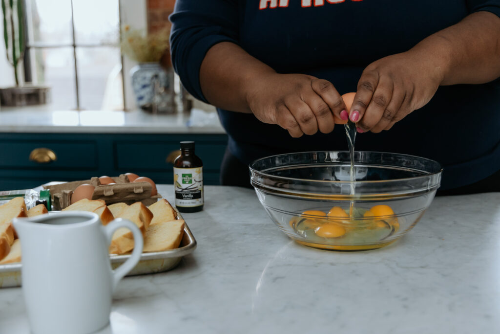 Cracking eggs in a bowl for french toast