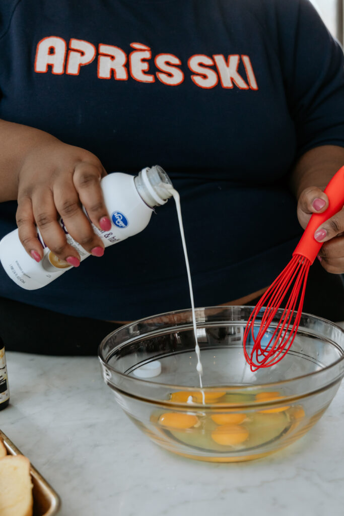 Whisking half and half into eggs.