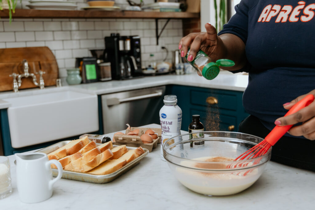 Adding cinnamon to custard mixture.