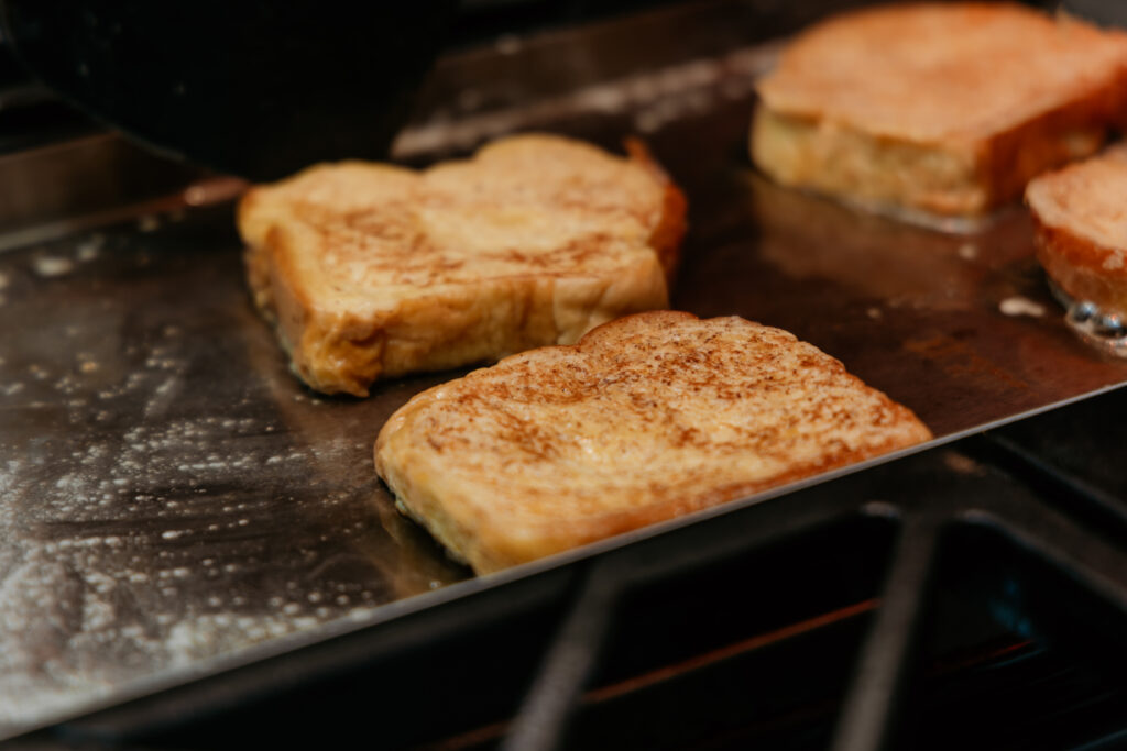 French toast that has been flipped on hot griddle.