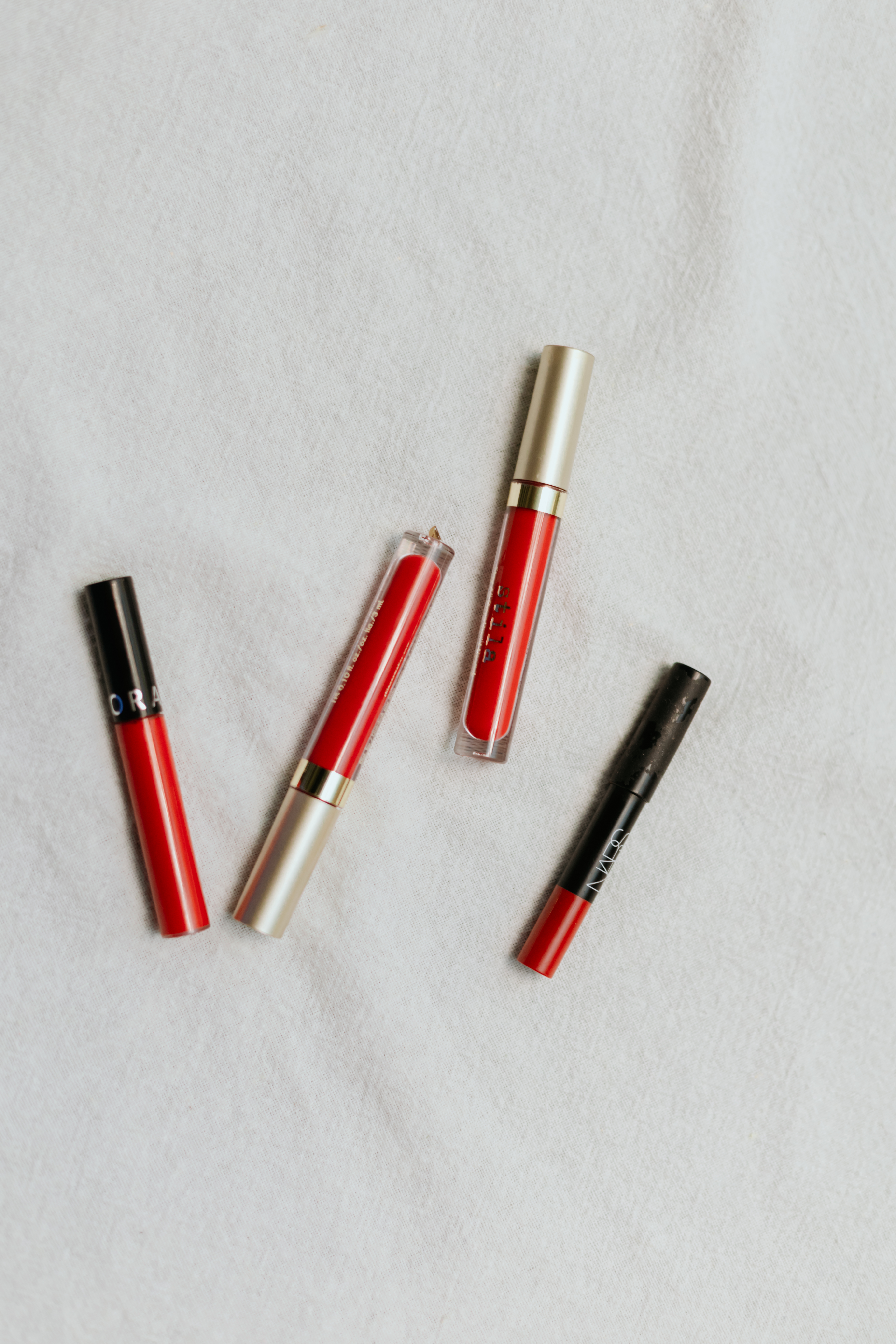 Red lip sticks for dark skin on a flat surface.