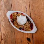 Mixed berry crisp topped with vanilla ice cream.