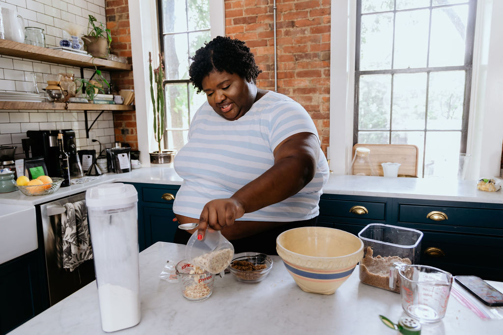 Kandice is pouring oats into a measuring cup.