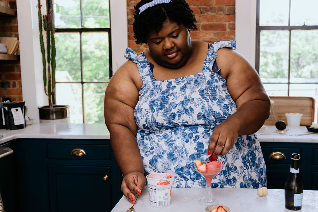 Kandice is adding more strawberries to the coupe glass.