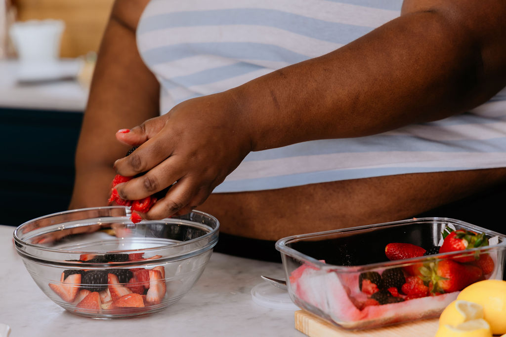 Kandice is pouring fresh fruit into a bowl.