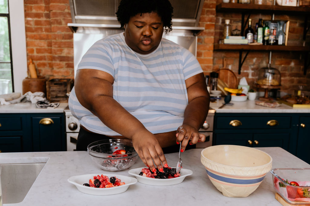 Kandice is placing fruit into ramekin,