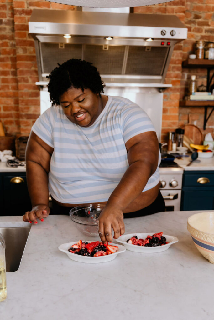 Mixed berry crisp fruit is being placed in greased baking dish,