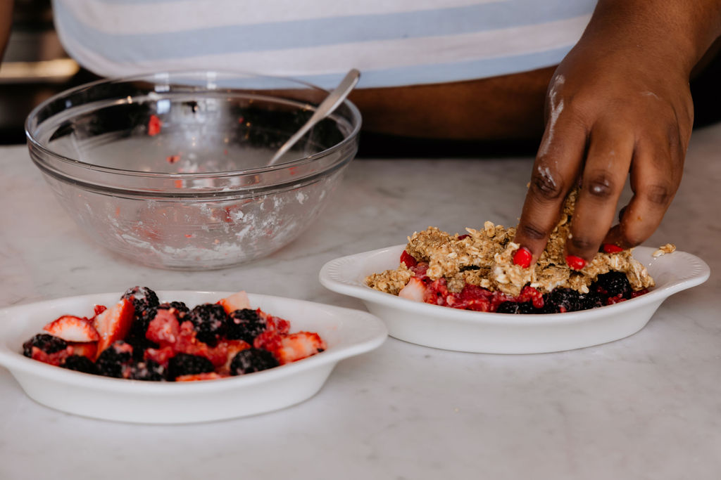 Kandice is placing crisp topping on fruit,