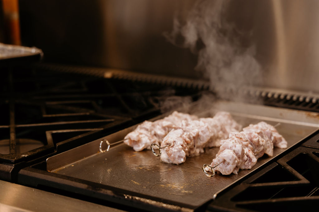 Chicken Gyro Skewers are cooking on grill.