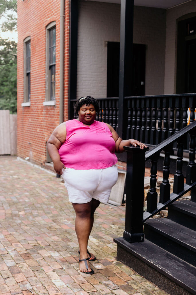 Kandice is wearing a Barbie Pink top with white denim shorts.