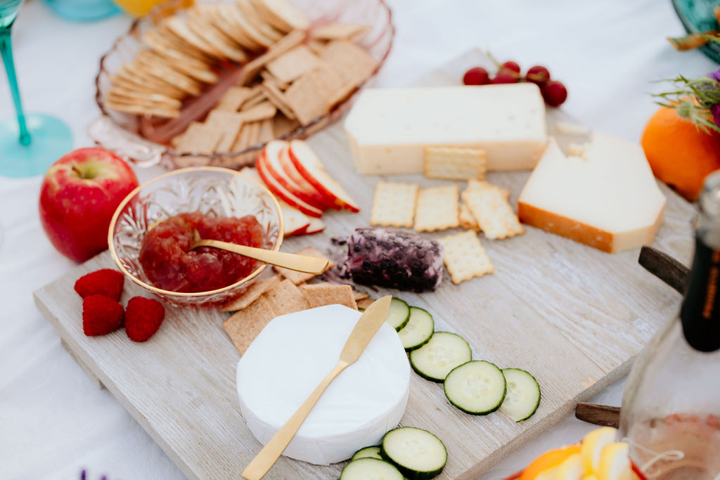 A summer picnic cheeseboard with fresh fruit, and crackers.