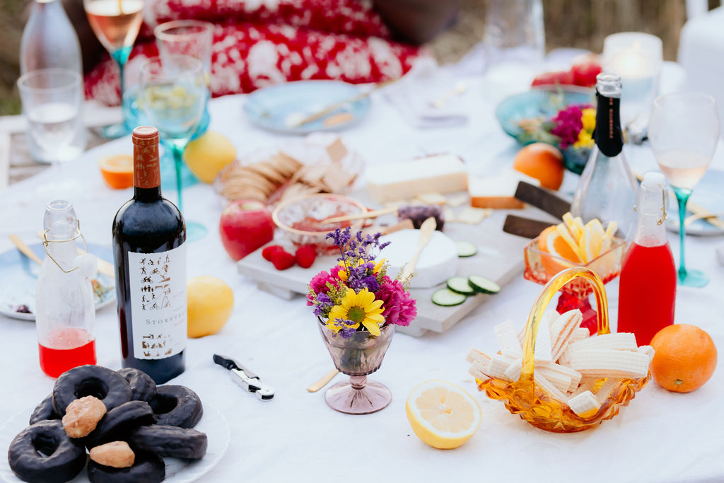 A tablescape of fruit, flowers, and food.