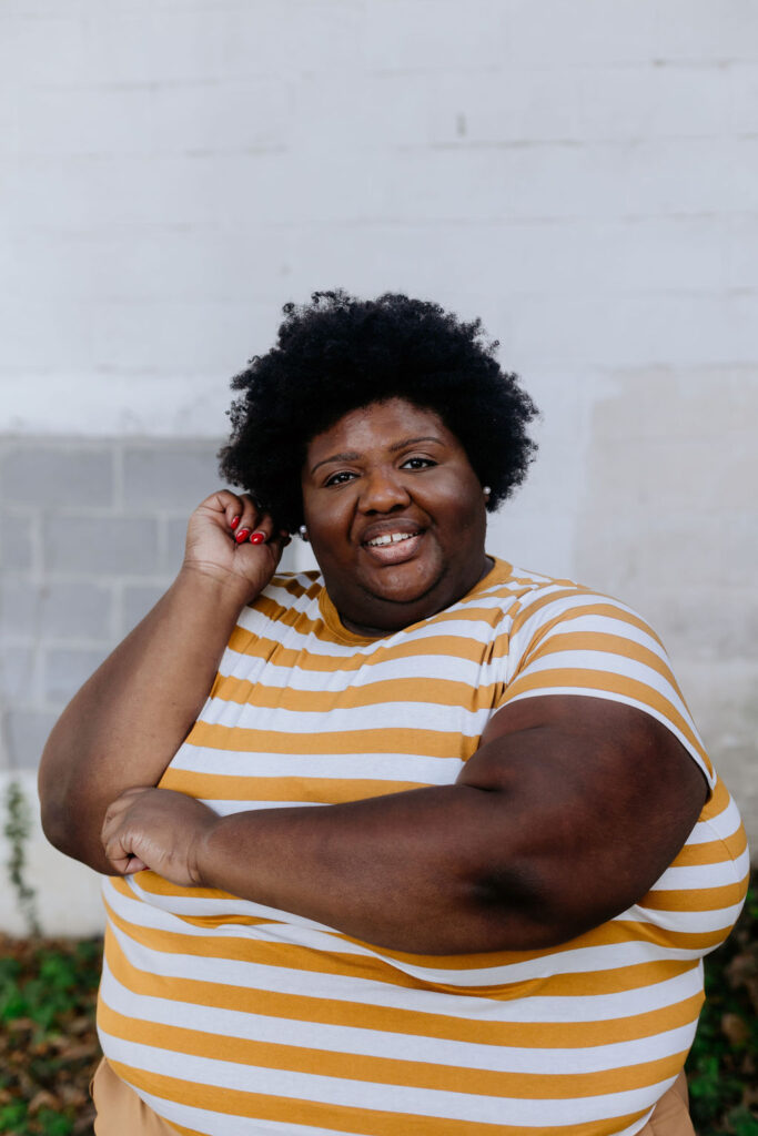 Kandice is posing in a striped shirt.