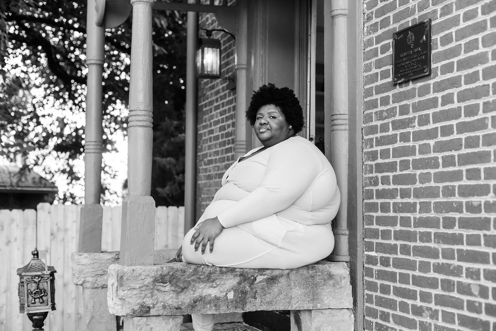 Kandice is sitting on porch steps.