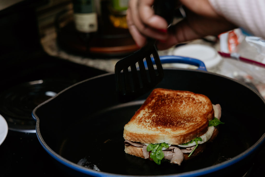 Toasted roast beef, spinach, and arugula panini in skillet.