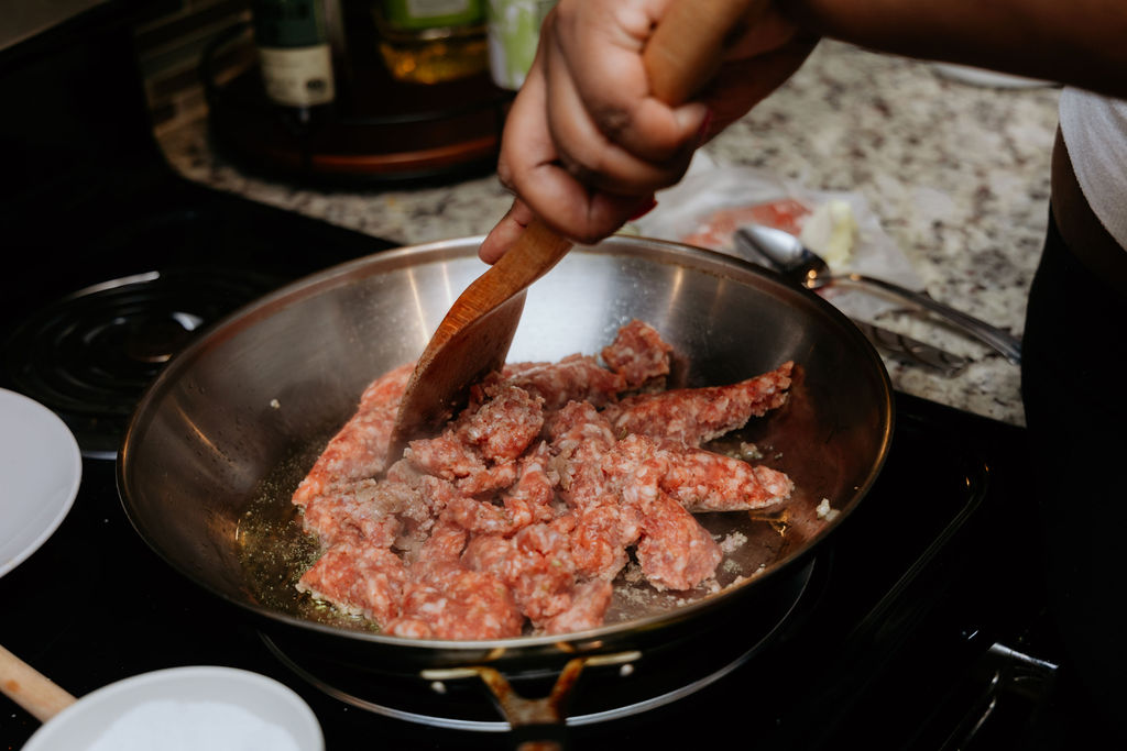 Kandice is browning meat for sauage spinach and mushroom pasta.