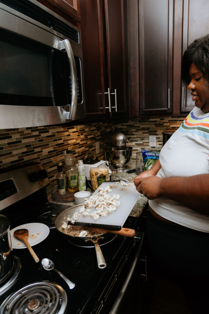 Kandice is adding mushrooms to sausage spinach and mushroom pasta.