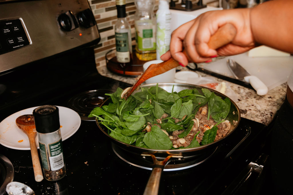 Kandice is stirring spinach.