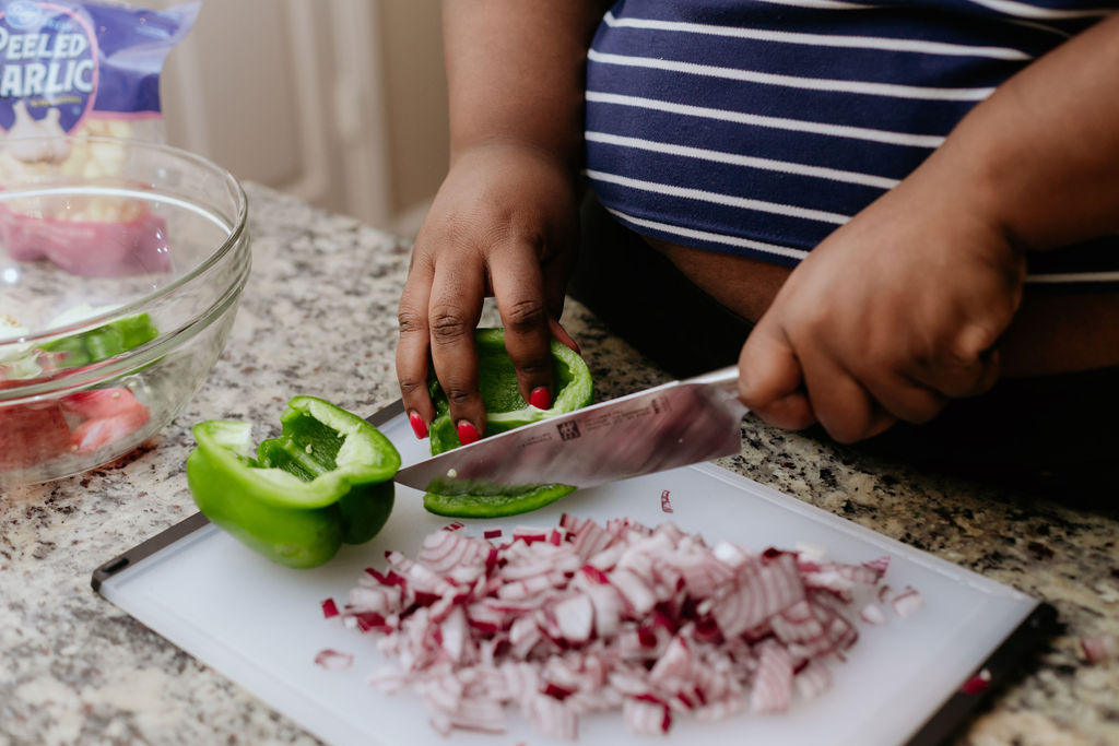 Kandice is chopping vegetables for beef and chorizo chili.