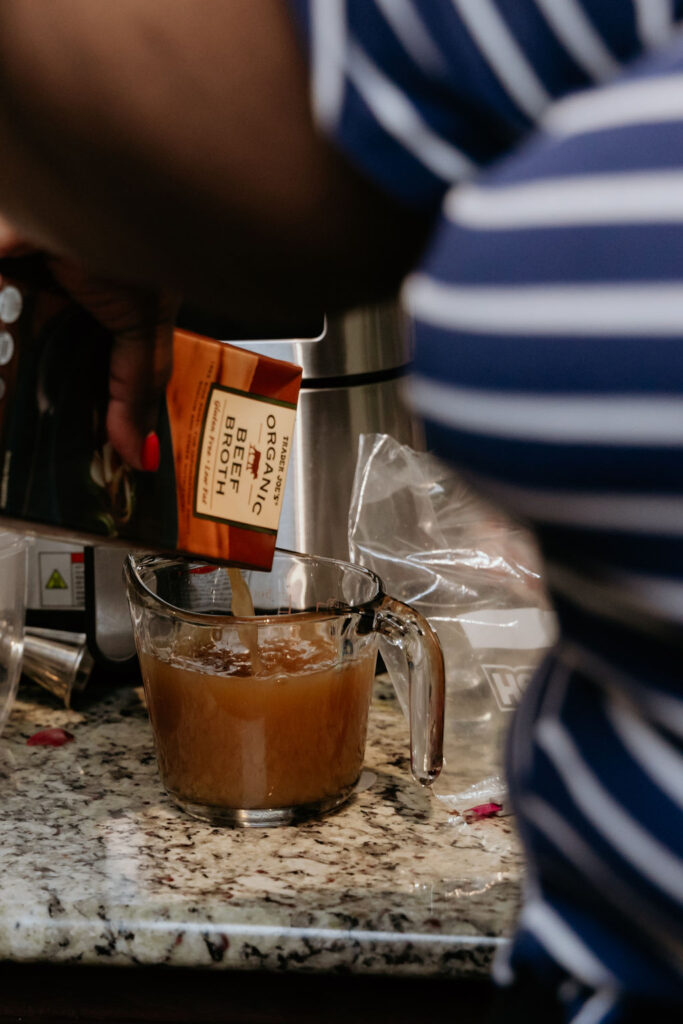 Kandice is adding beef broth to chili.